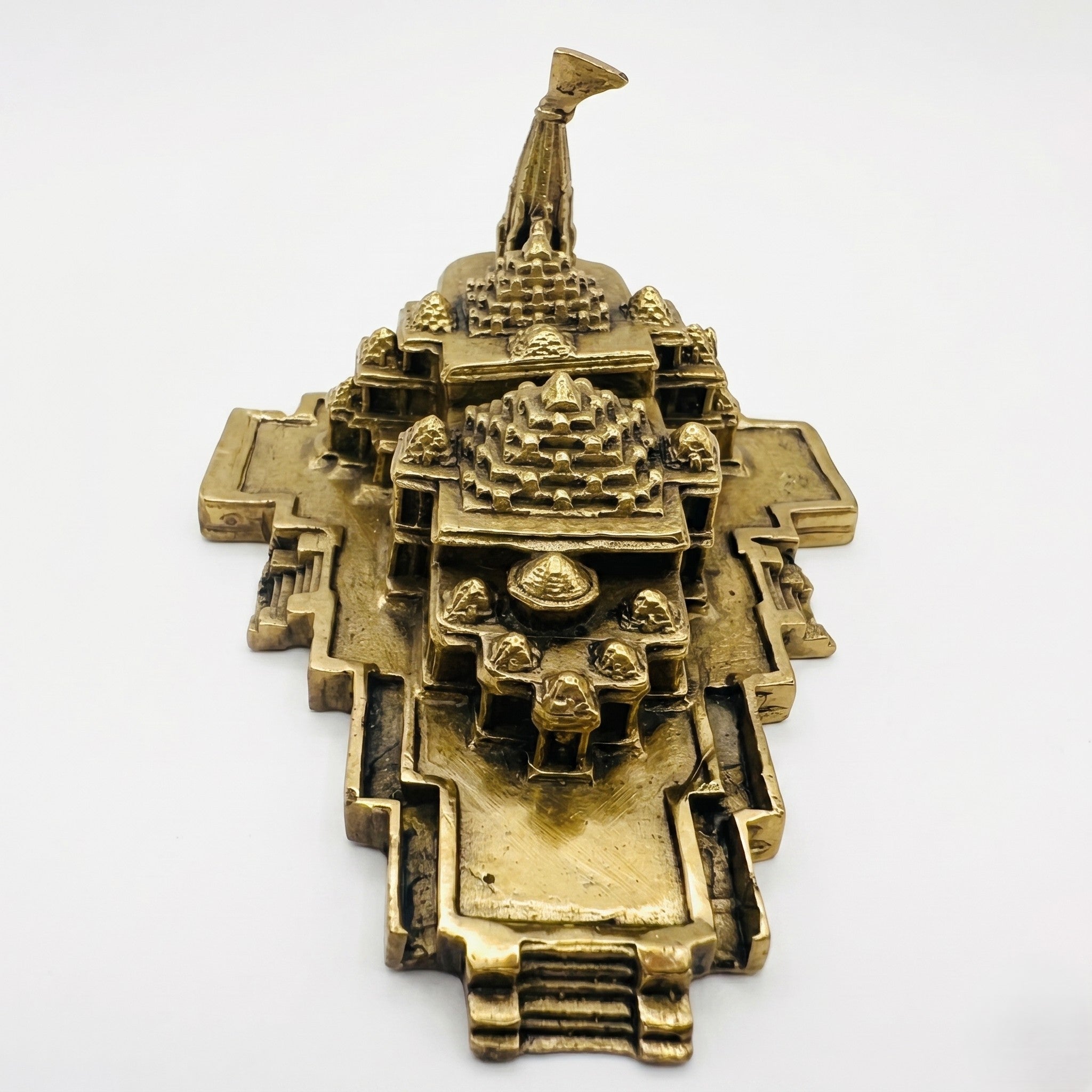Svarn Studio Brass Ram Mandir - Hero car dashboard lifestyle: Ram Mandir miniature on luxury car dashboard with marigold flowers and brass diya, warm bokeh background, Svarn Studio branding